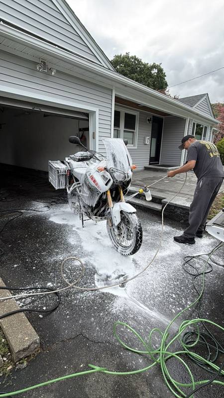 Valley Cleans foam-washing a motorcycle in a client's driveway